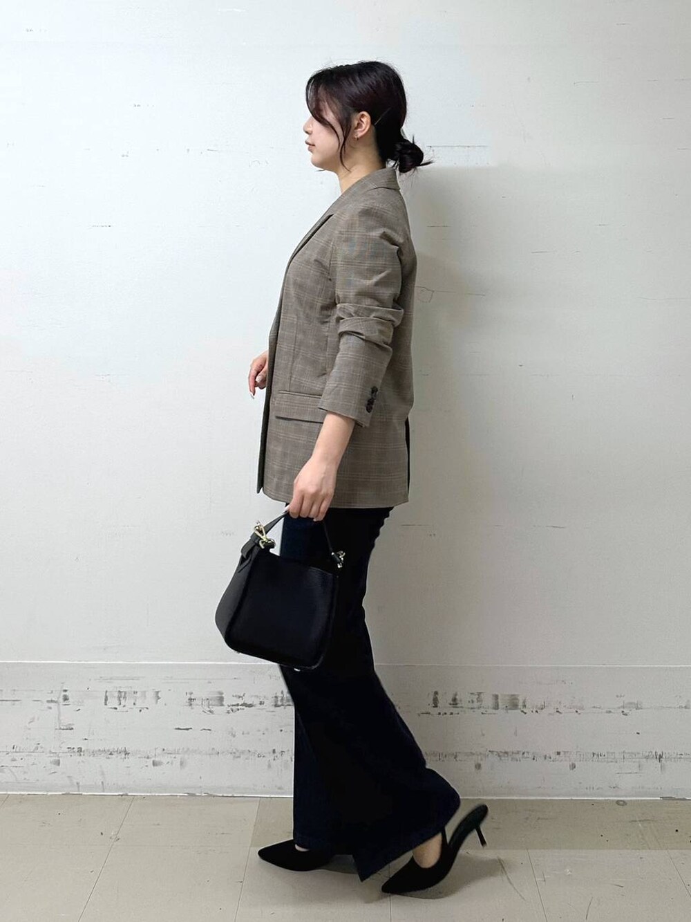 ブラック系のハンドバッグ、ブラック系のキャミソール、ブルー系のデニムパンツを着用したレディースの夏コーディネートの2枚目の写真