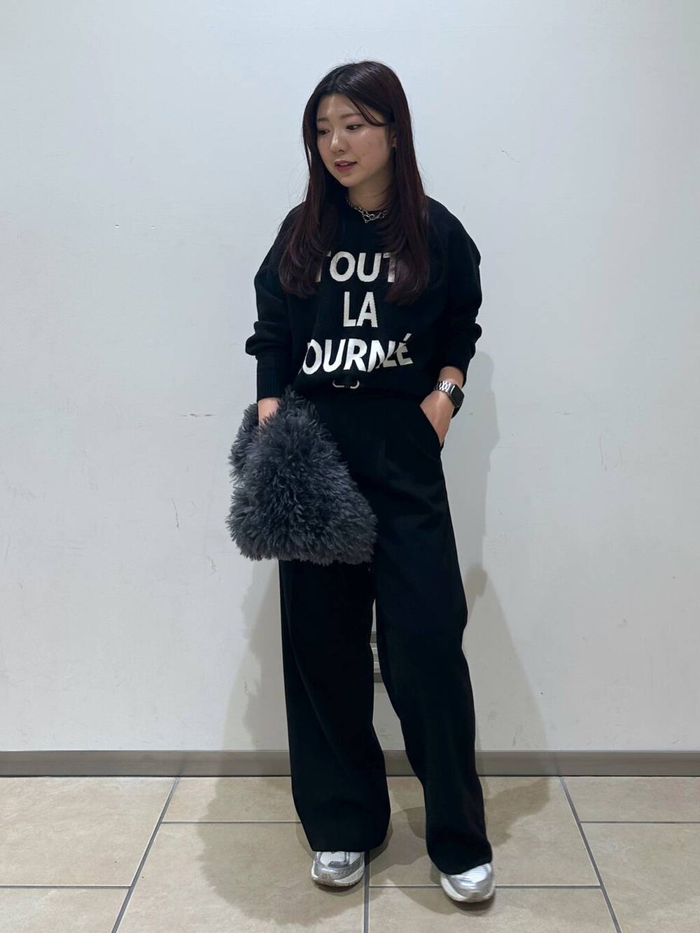 グレー系のトートバッグ、ブラック系のスラックス、ブラック系のニット/セーターを着用したレディースの冬コーディネートの4枚目の写真