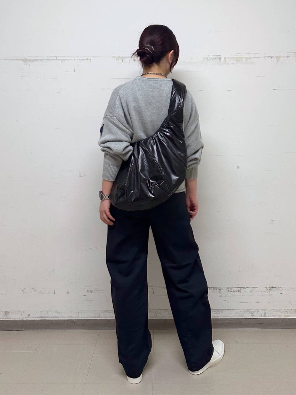 グレー系のニット/セーター、ブラック系のショルダーバッグ、グレー系のチノパンツを着用したレディースの秋コーディネートの3枚目の写真