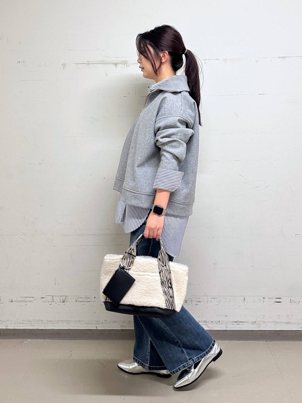 シルバー系のローファー、ブルー系のシャツ/ブラウス、ホワイト系のトートバッグを着用したレディースの冬コーディネートの2枚目の写真