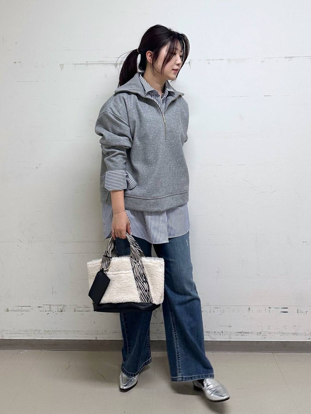 シルバー系のローファー、ブルー系のシャツ/ブラウス、ホワイト系のトートバッグを着用したレディースの冬コーディネートの4枚目の写真