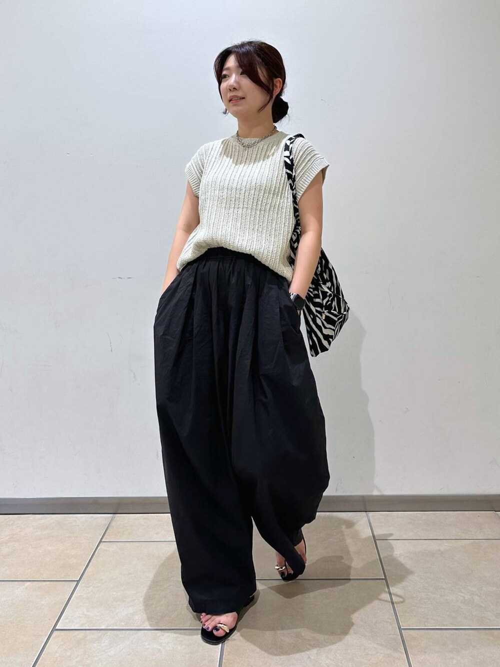 ブラック系のその他パンツ、ブラック系のサンダル、ベージュ系のニット/セーターを着用したレディースの夏コーディネートの4枚目の写真