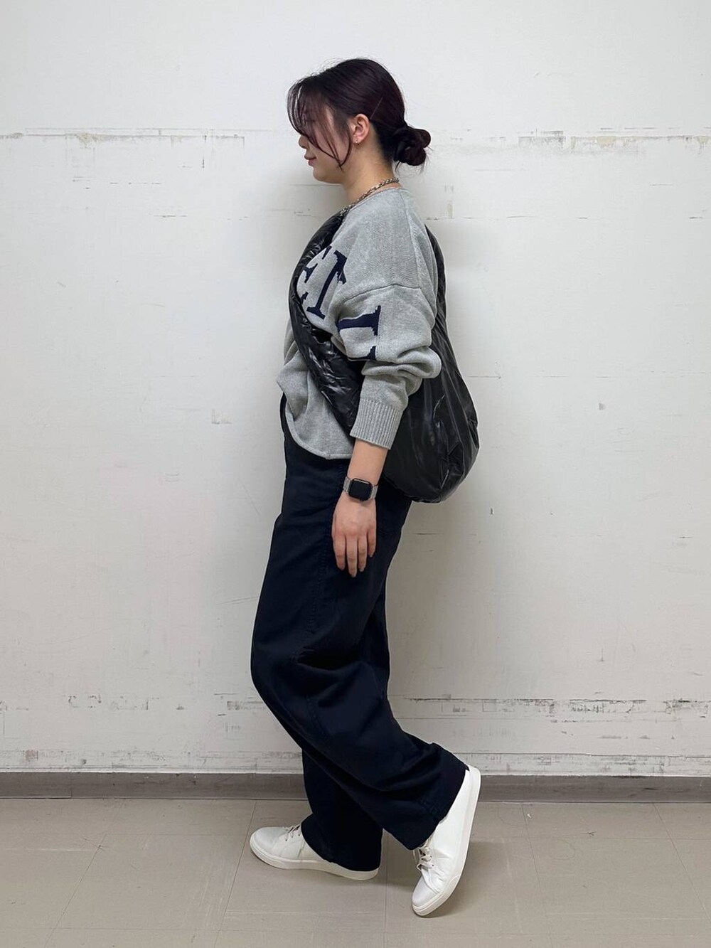 グレー系のニット/セーター、ブラック系のショルダーバッグ、グレー系のチノパンツを着用したレディースの秋コーディネートの2枚目の写真