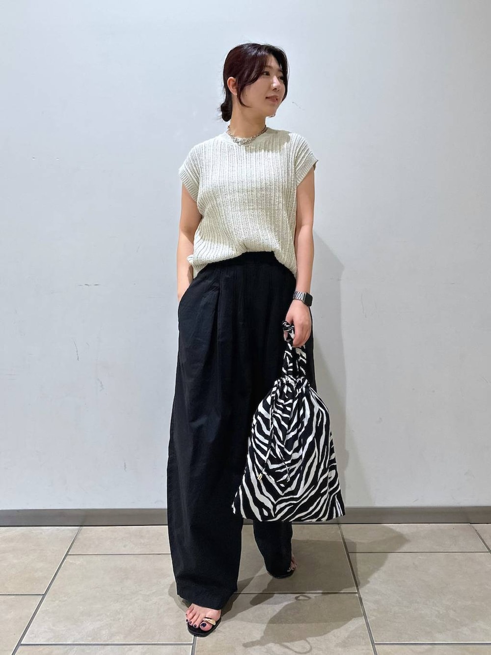 ブラック系のその他パンツ、ブラック系のサンダル、ベージュ系のニット/セーターを着用したレディースの夏コーディネートの5枚目の写真