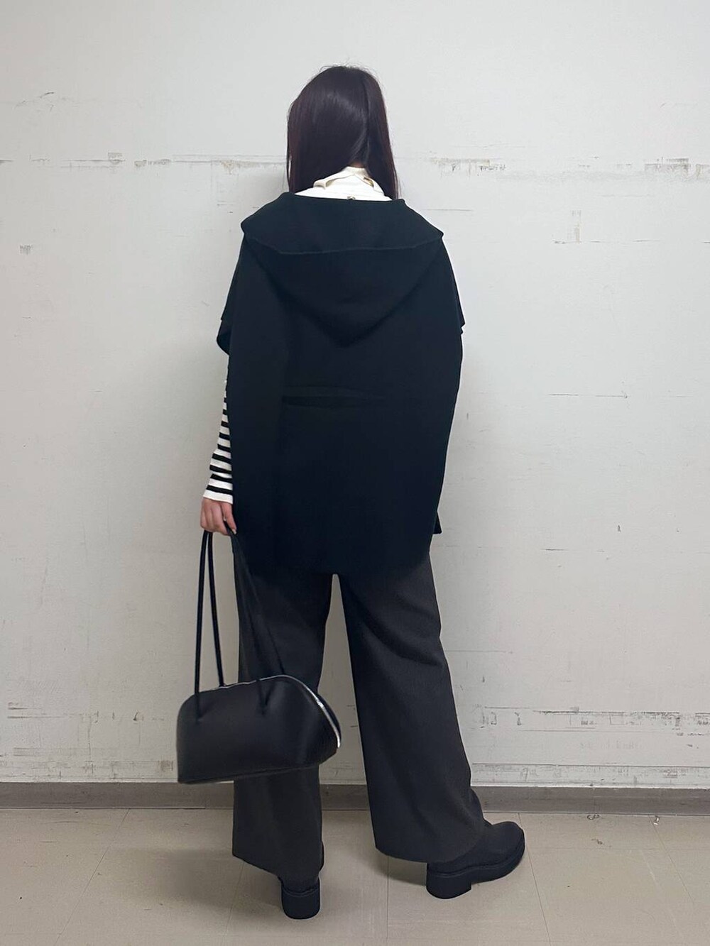 ブラック系のブルゾン、グレー系のパーカー、ブラック系のブーツを着用したレディースの秋コーディネートの3枚目の写真