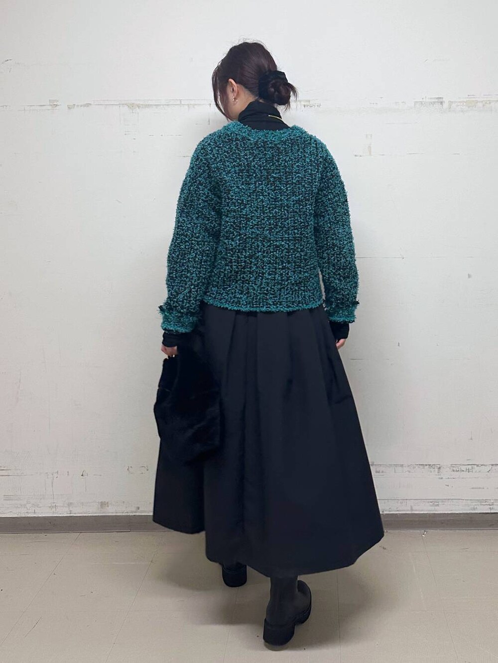 ブラック系のTシャツ/カットソー、ブラック系のトートバッグ、ブラック系のブーツを着用したレディースの冬コーディネートの3枚目の写真