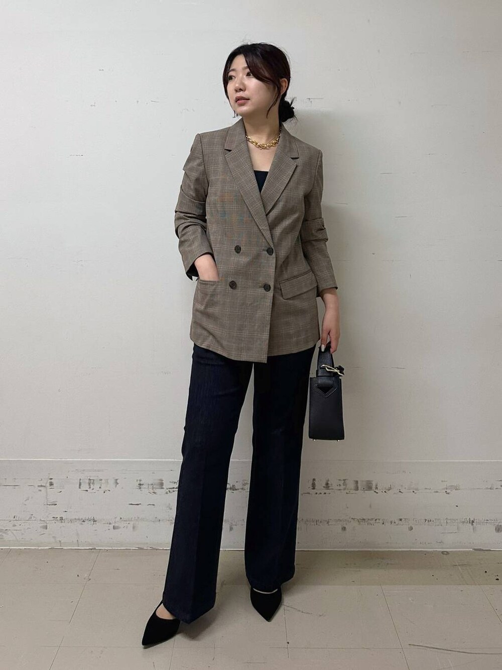 ブラック系のハンドバッグ、ブラック系のキャミソール、ブルー系のデニムパンツを着用したレディースの夏コーディネートの4枚目の写真