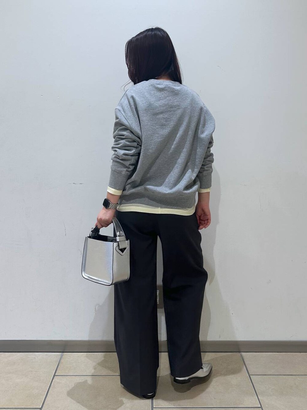 シルバー系のローファー、ベージュ系のTシャツ/カットソー、シルバー系のショルダーバッグを着用したレディースの冬コーディネートの3枚目の写真