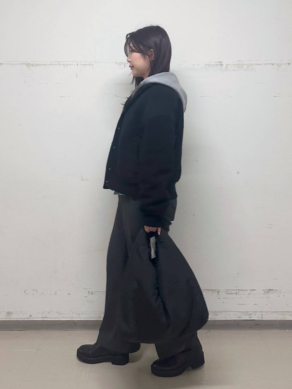 ブラック系のブルゾン、グレー系のパーカー、ブラック系のブーツを着用したレディースの秋コーディネートの2枚目の写真