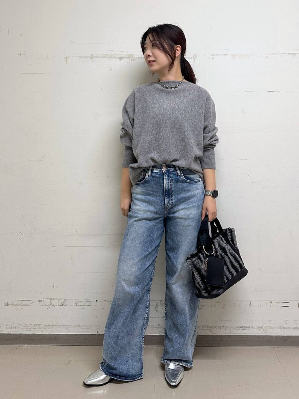 ブルー系のデニムパンツ、シルバー系のローファー、グレー系のトートバッグを着用したレディースの秋コーディネートの4枚目の写真