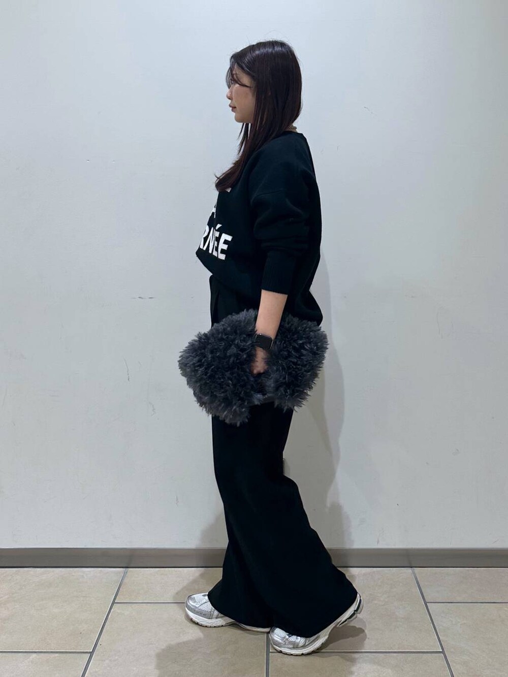 グレー系のトートバッグ、ブラック系のスラックス、ブラック系のニット/セーターを着用したレディースの冬コーディネートの2枚目の写真