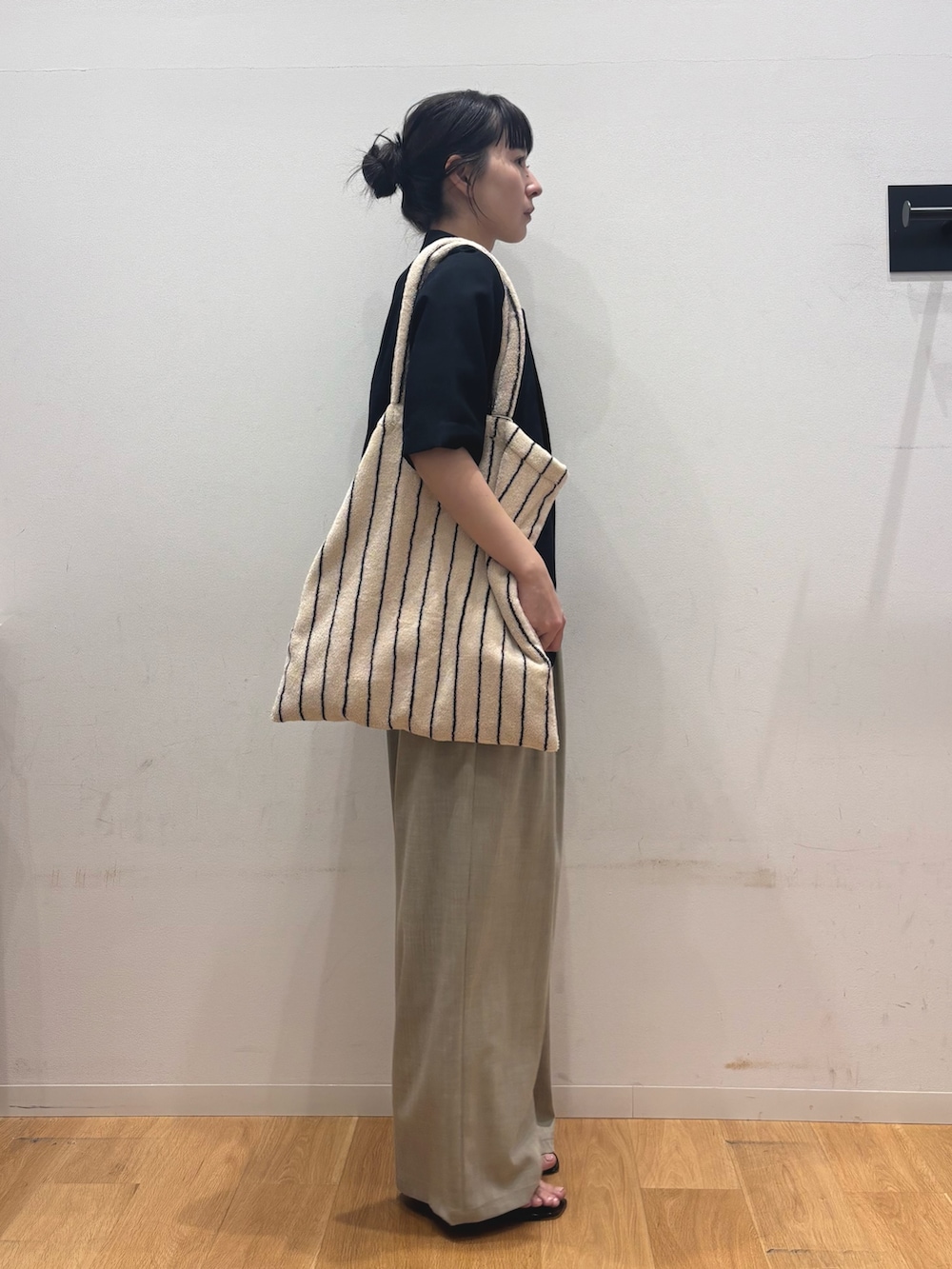 ベージュ系のその他パンツ、ブラック系のサンダル、ベージュ系のトートバッグを着用したレディースの夏コーディネートの4枚目の写真