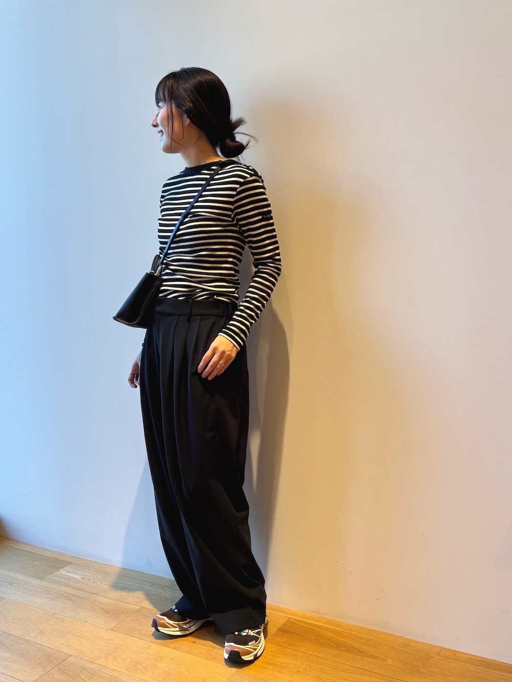 ブラック系のその他パンツ、ブラウン系のスニーカー、ブラック系のハンドバッグを着用したレディースの夏コーディネートの2枚目の写真