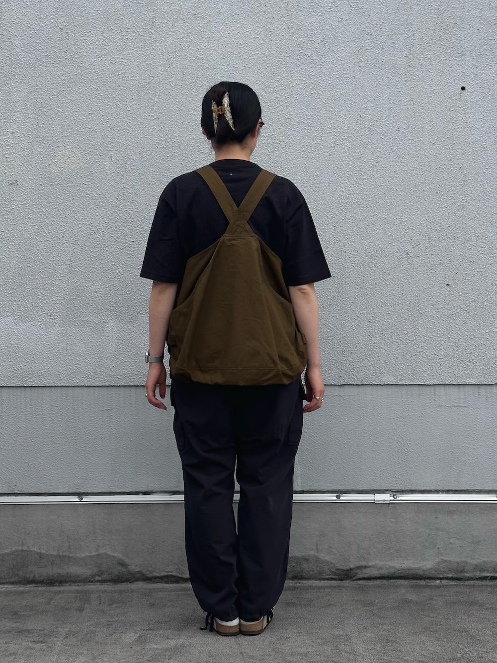 ブラック系のTシャツ/カットソー、グリーン系のベスト、ブラック系のその他パンツを着用したレディースの夏コーディネートの3枚目の写真