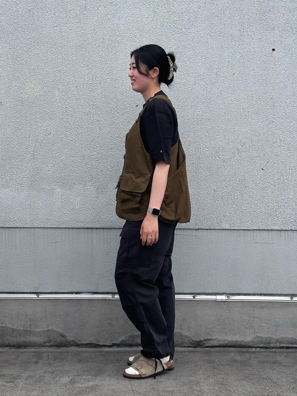 ブラック系のTシャツ/カットソー、グリーン系のベスト、ブラック系のその他パンツを着用したレディースの夏コーディネートの2枚目の写真