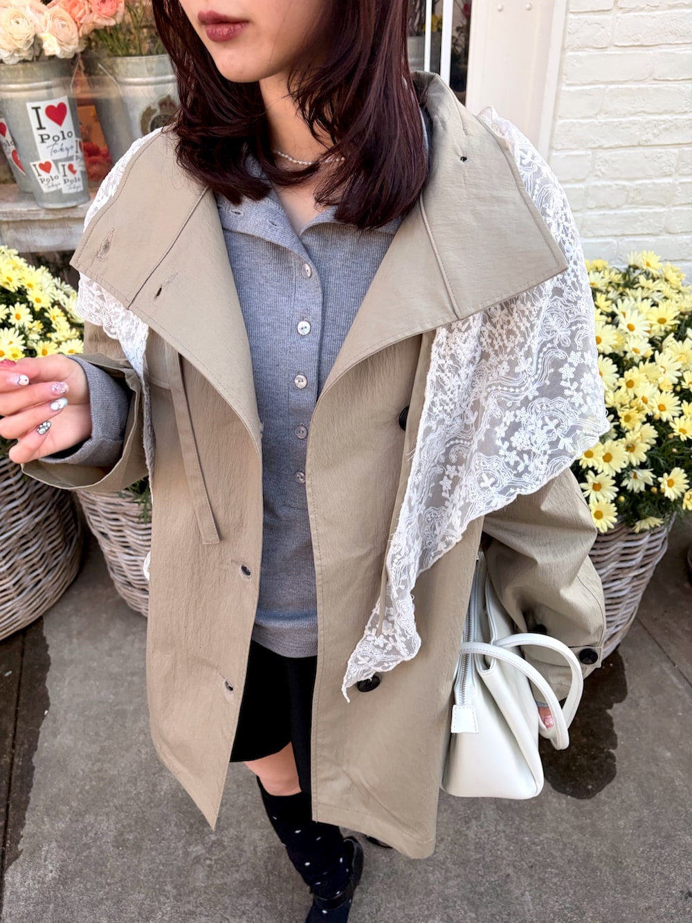 ベージュ系のトレンチコート、グレー系のTシャツ/カットソー、ブラック系のソックス/靴下を着用したレディースの冬コーディネートの3枚目の写真