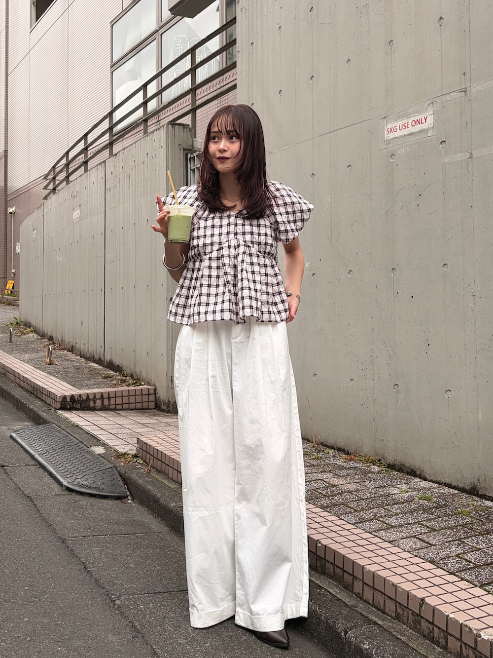 ベージュ系のシャツ/ブラウス、ブラック系のトートバッグを着用したレディースの春コーディネートの5枚目の写真