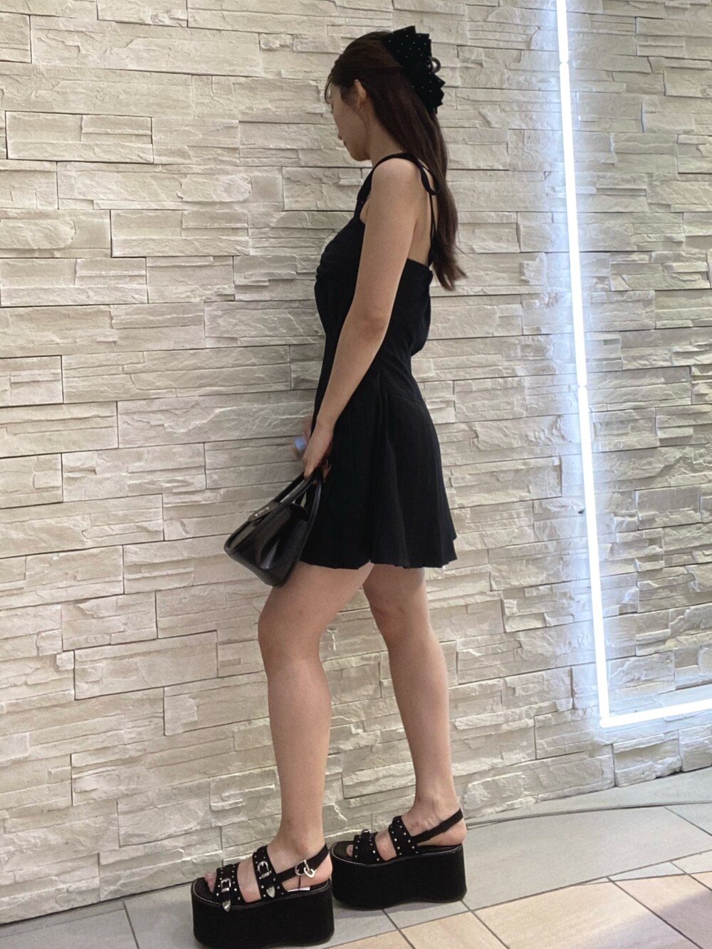 ブラック系のワンピース、その他のハンドバッグを着用したレディースの夏コーディネートの2枚目の写真