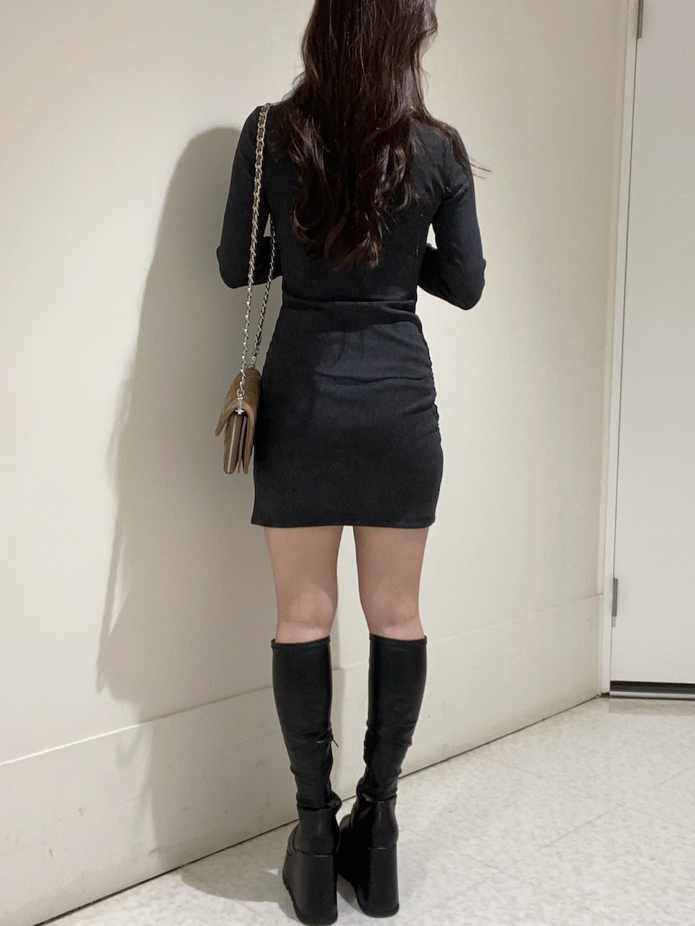 ブラック系のワンピース、ブラック系のブーツを着用したレディースの秋コーディネートの3枚目の写真