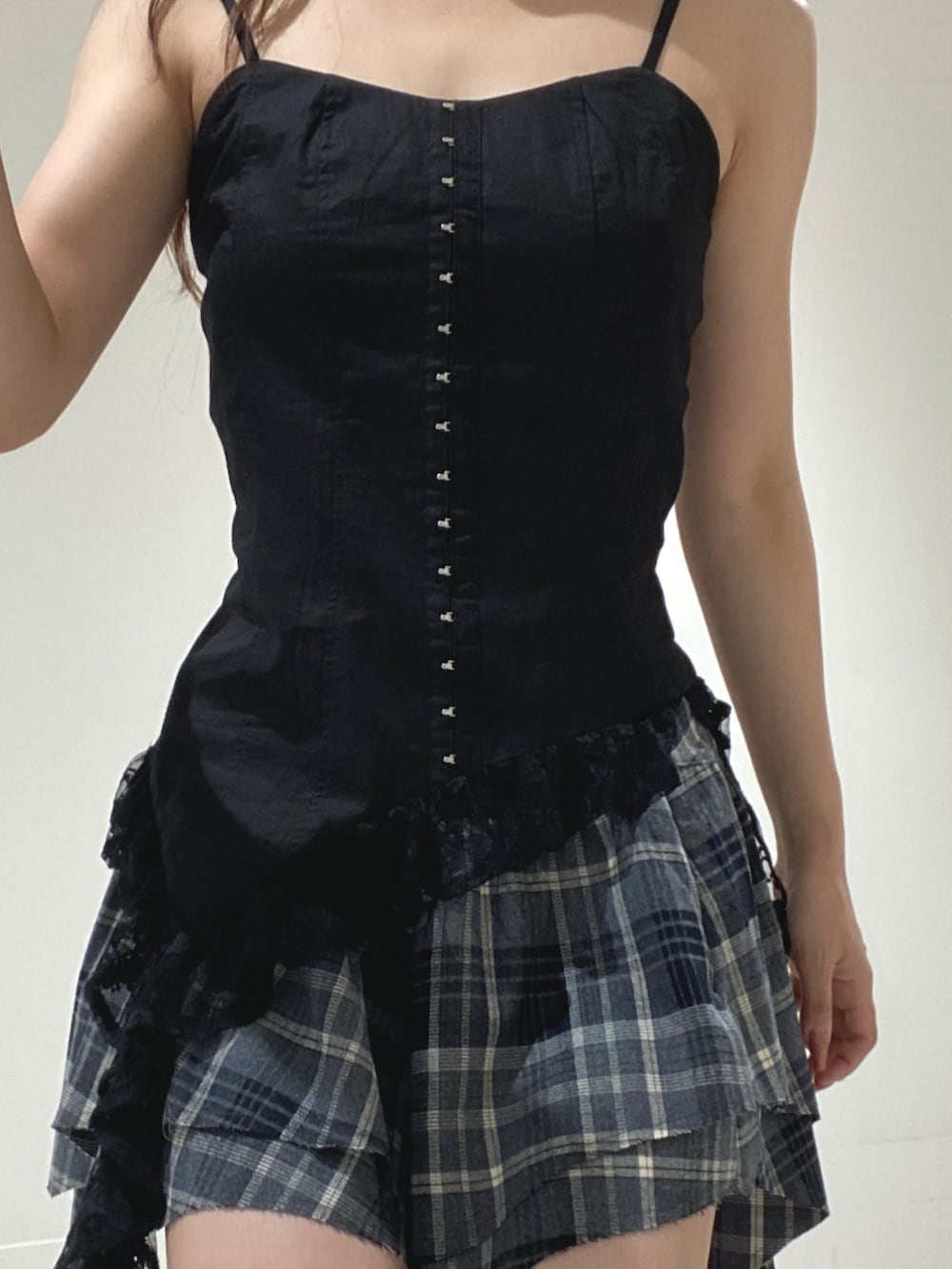 ブラック系のキャミソール、ブラック系のスカート、ブラック系のブーツを着用したレディースの夏コーディネートの4枚目の写真