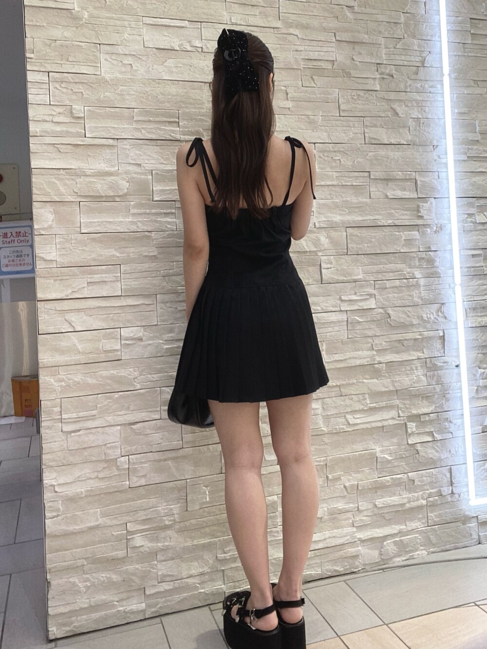 ブラック系のワンピース、その他のハンドバッグを着用したレディースの夏コーディネートの3枚目の写真