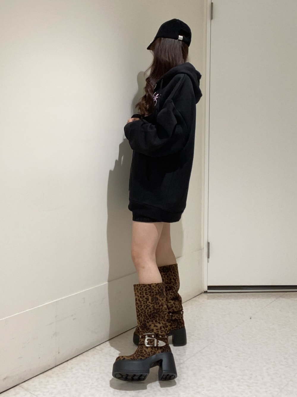 ブラック系のパーカー、その他のブーツ、ブラック系のキャップを着用したレディースの秋コーディネートの3枚目の写真