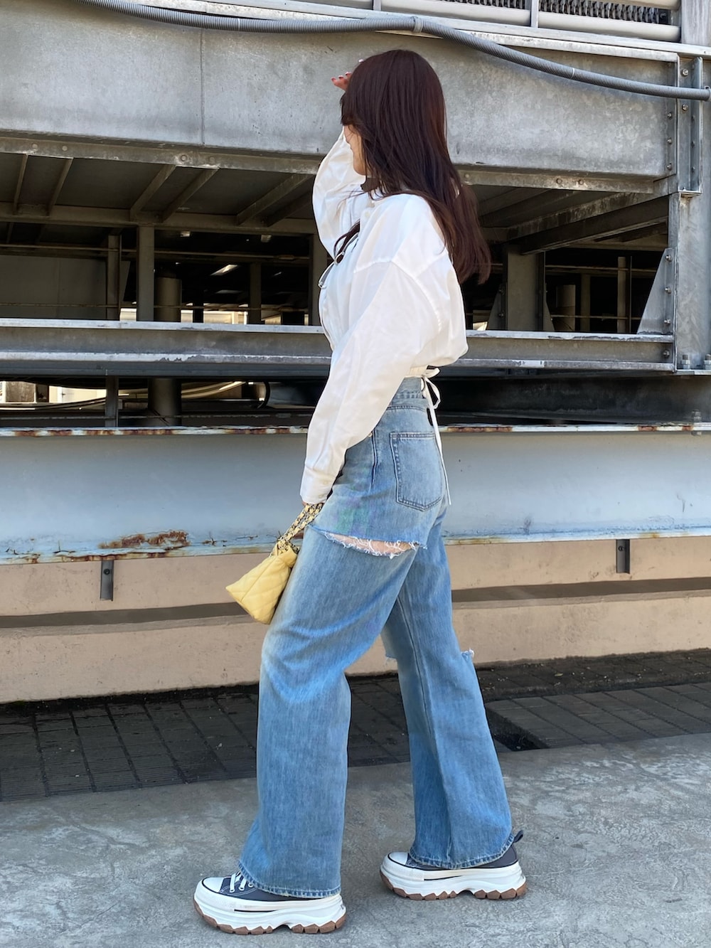 ブルー系のデニムパンツ、ホワイト系のシャツ/ブラウス、イエロー系のショルダーバッグを着用したレディースの春コーディネートの2枚目の写真