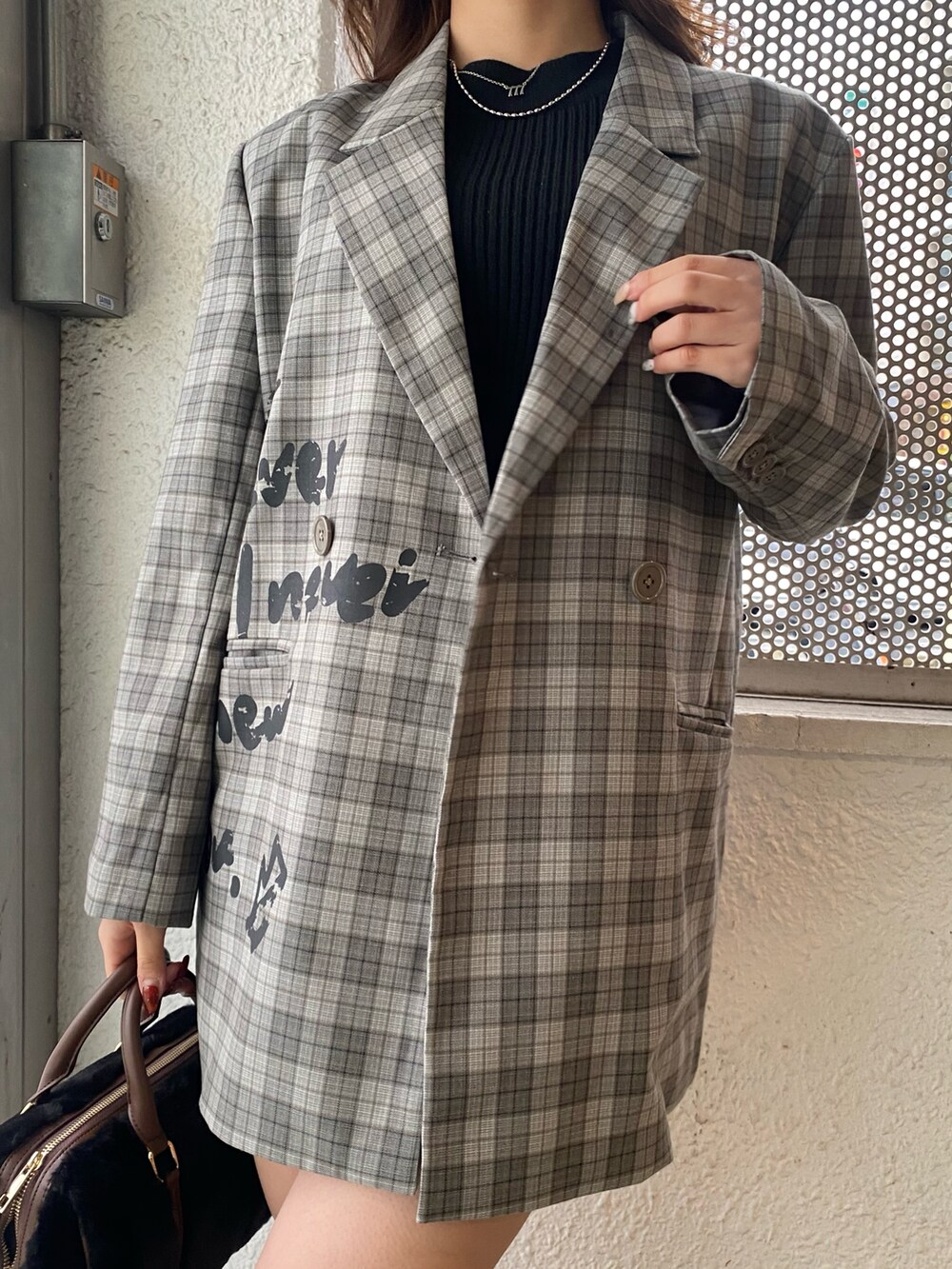 グレー系のテーラードジャケット、ブラック系のデニムスカート、ブラック系のブーツを着用したレディースの冬コーディネートの4枚目の写真