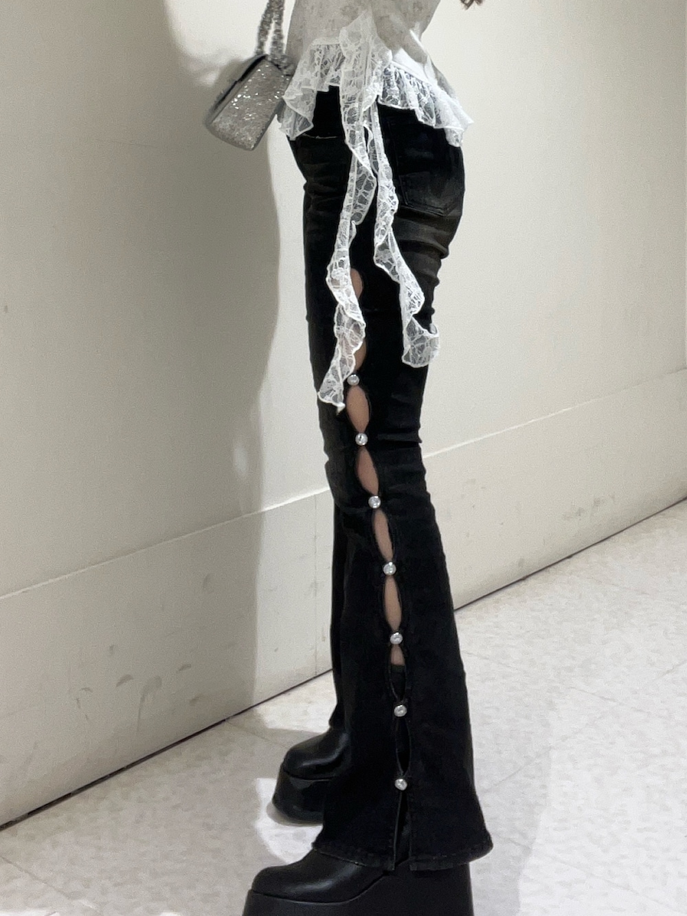 シルバー系のショルダーバッグ、ホワイト系のTシャツ/カットソー、ブラック系のデニムパンツを着用したレディースの冬コーディネートの5枚目の写真