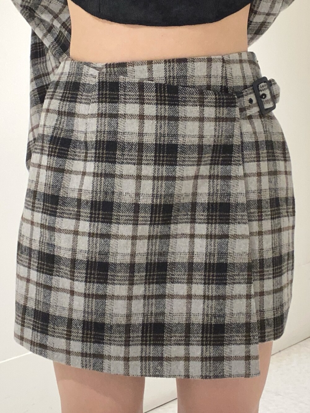 グレー系のテーラードジャケット、グレー系のスカート、ブラック系のブーツを着用したレディースの秋コーディネートの5枚目の写真