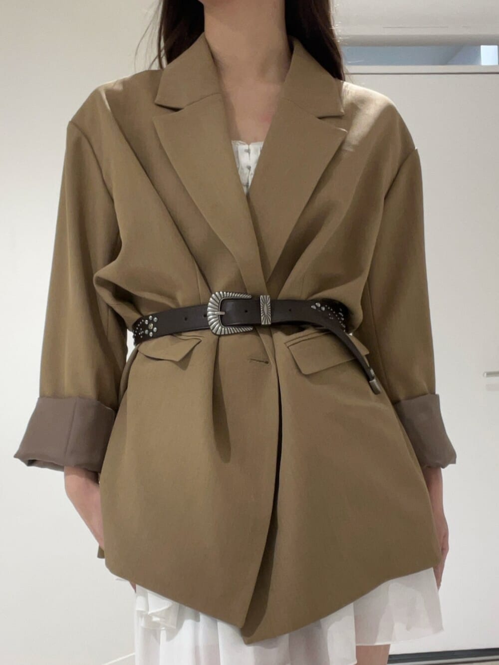 ブラウン系のテーラードジャケット、ホワイト系のワンピース、ブラウン系のベルトを着用したレディースの春コーディネートの4枚目の写真