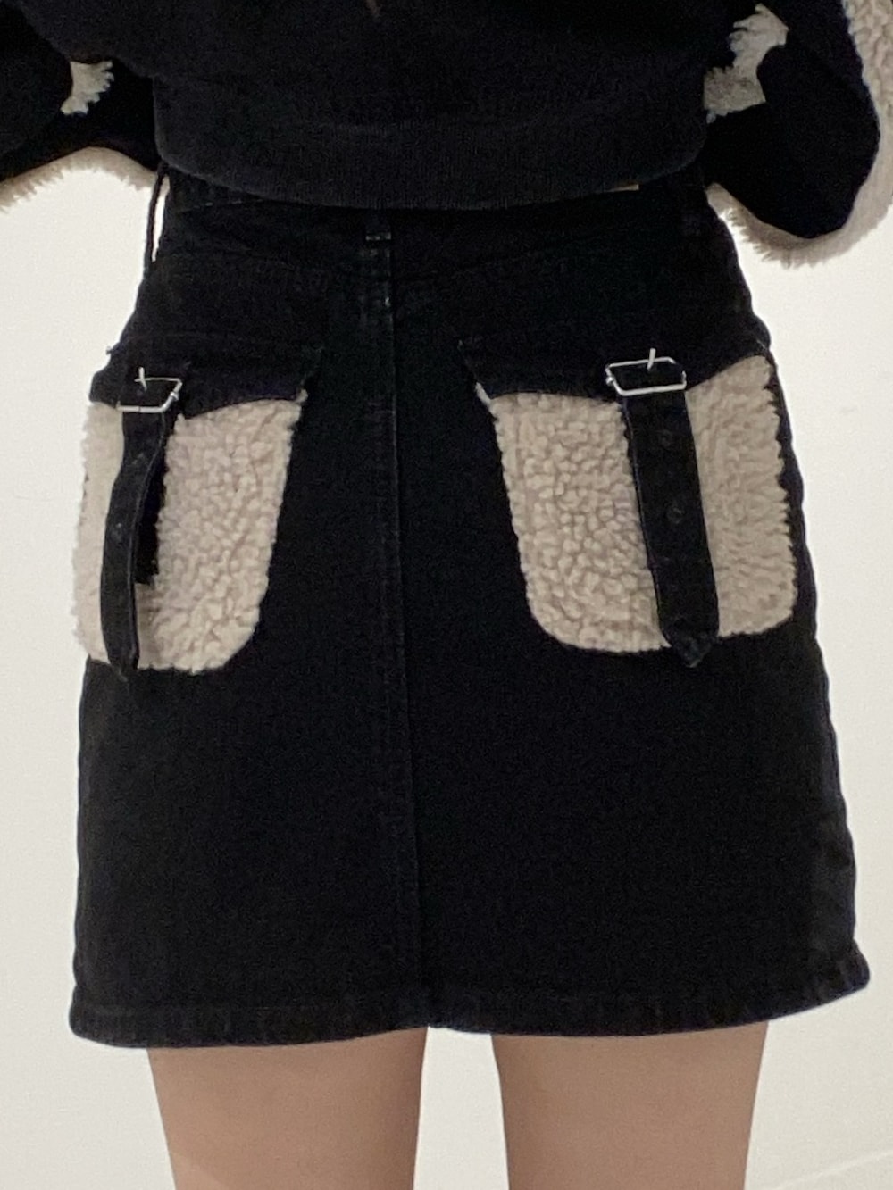 ブラック系のブルゾン、ブラック系のデニムスカート、ブラック系のブーツを着用したレディースの秋コーディネートの5枚目の写真