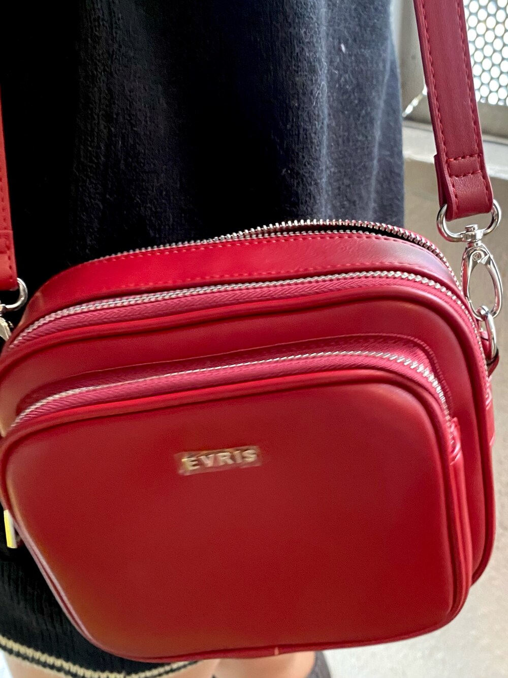 ブラック系のニット/セーター、レッド系のショルダーバッグ、グレー系のレッグウォーマーを着用したレディースの冬コーディネートの6枚目の写真