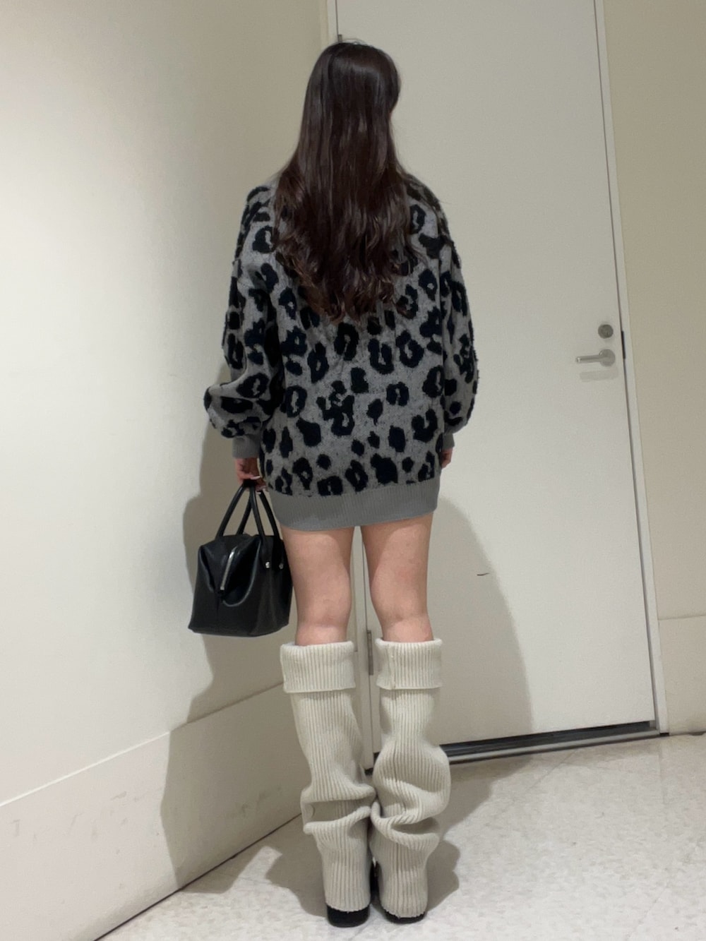 グレー系のカーディガン/ボレロ、ブラウン系のボストンバッグ、ブラック系のブーツを着用したレディースの冬コーディネートの3枚目の写真