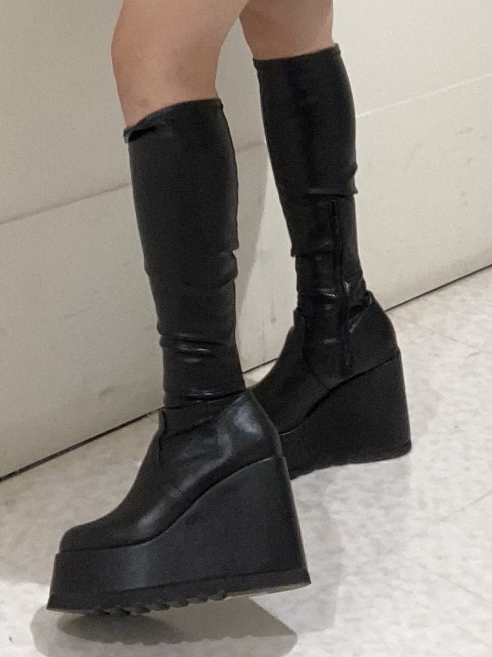 ブラック系のワンピース、ブラック系のブーツを着用したレディースの秋コーディネートの4枚目の写真