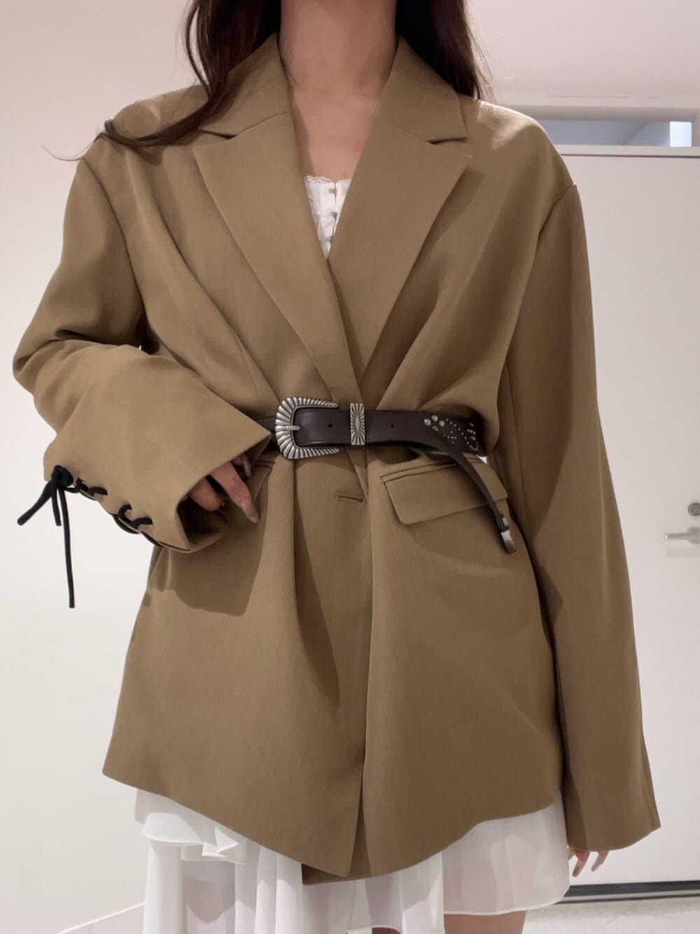 ブラウン系のテーラードジャケット、ホワイト系のワンピース、ブラウン系のベルトを着用したレディースの春コーディネートの5枚目の写真