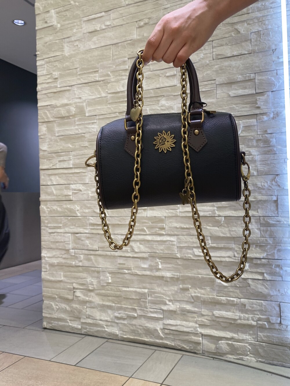 ブラック系のニット/セーター、ブルー系のデニムパンツ、その他のショルダーバッグを着用したレディースの夏コーディネートの5枚目の写真