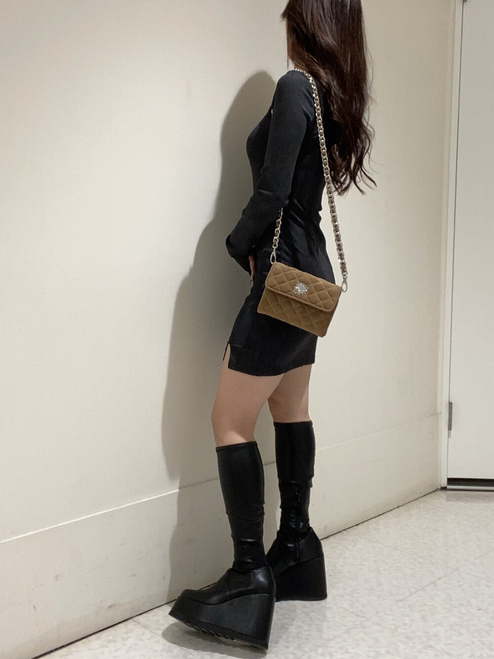 ブラック系のワンピース、ブラック系のブーツを着用したレディースの秋コーディネートの2枚目の写真