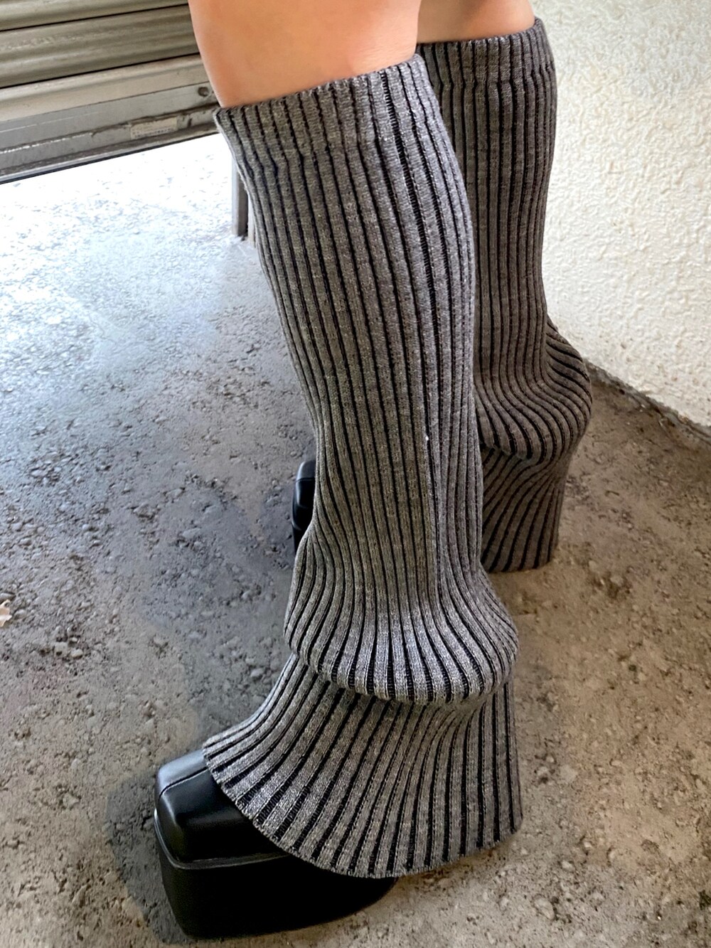 ブラック系のニット/セーター、レッド系のショルダーバッグ、グレー系のレッグウォーマーを着用したレディースの冬コーディネートの5枚目の写真