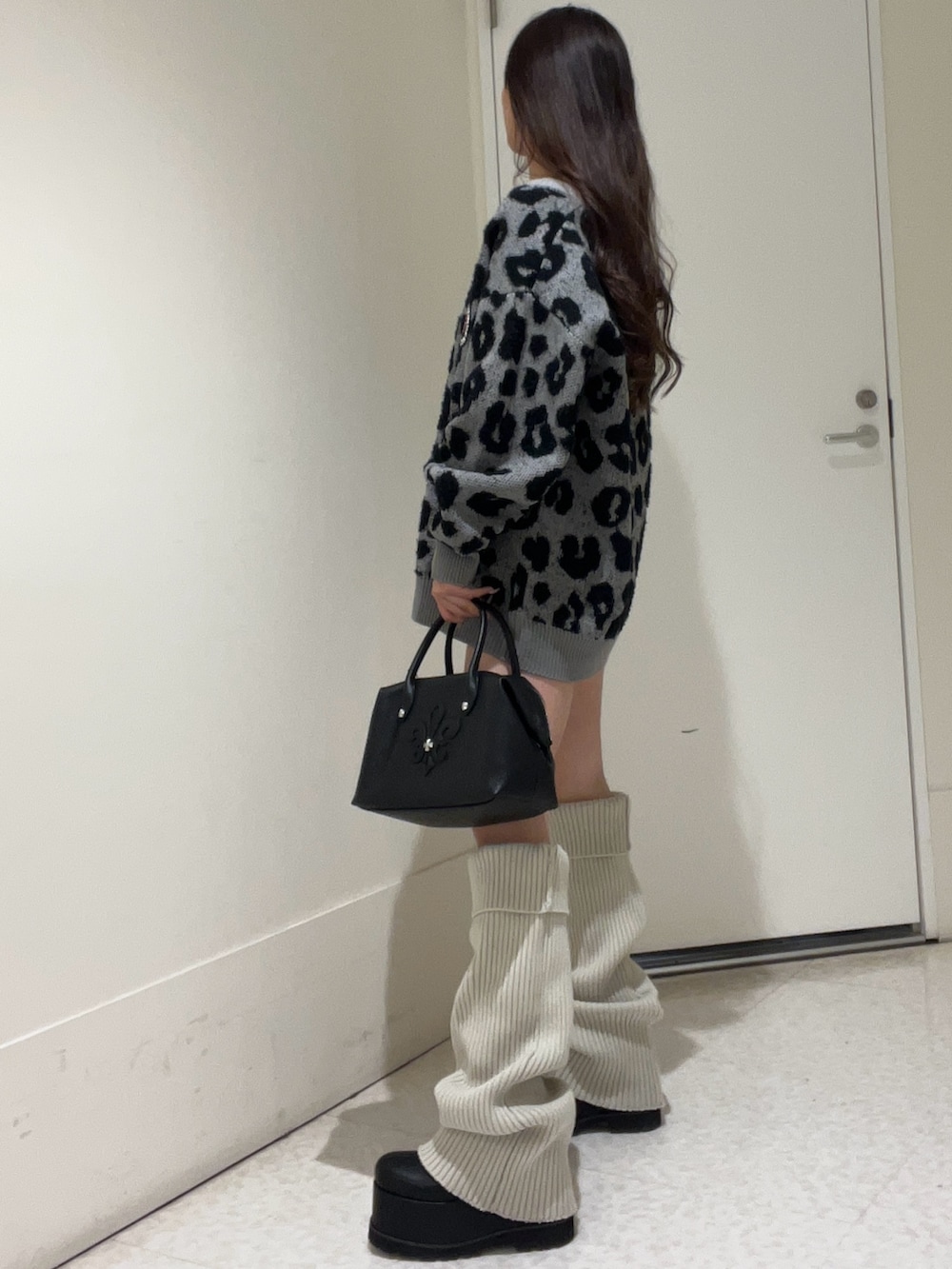 グレー系のカーディガン/ボレロ、ブラウン系のボストンバッグ、ブラック系のブーツを着用したレディースの冬コーディネートの2枚目の写真