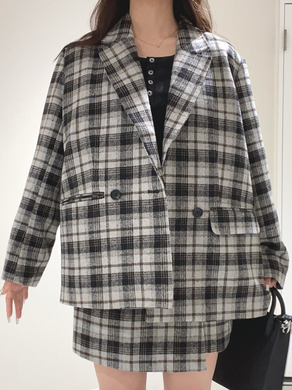 グレー系のテーラードジャケット、グレー系のスカート、ブラック系のブーツを着用したレディースの秋コーディネートの4枚目の写真