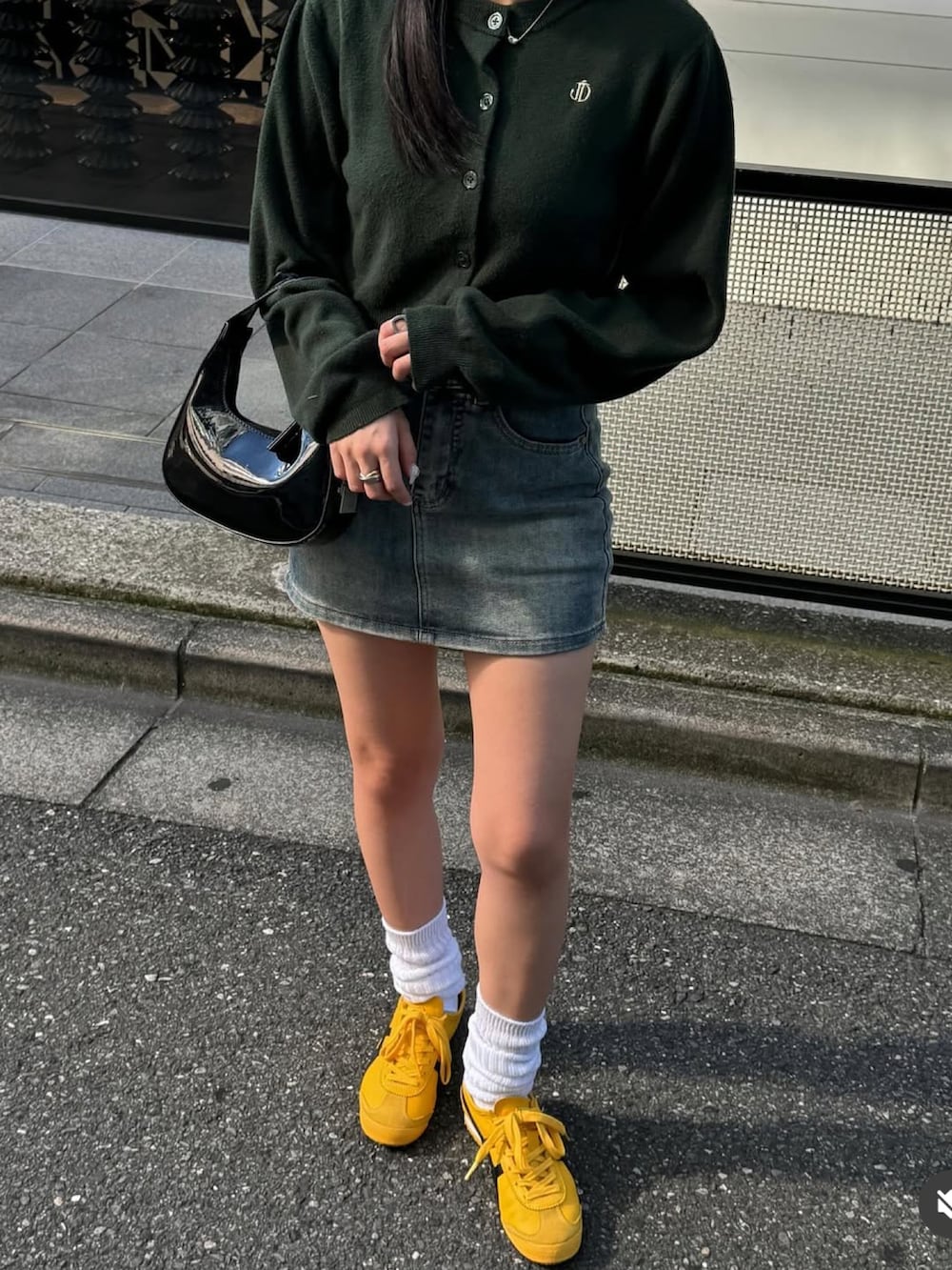 グリーン系のカーディガン/ボレロ、イエロー系のスニーカーを着用したレディースの冬コーディネートの3枚目の写真