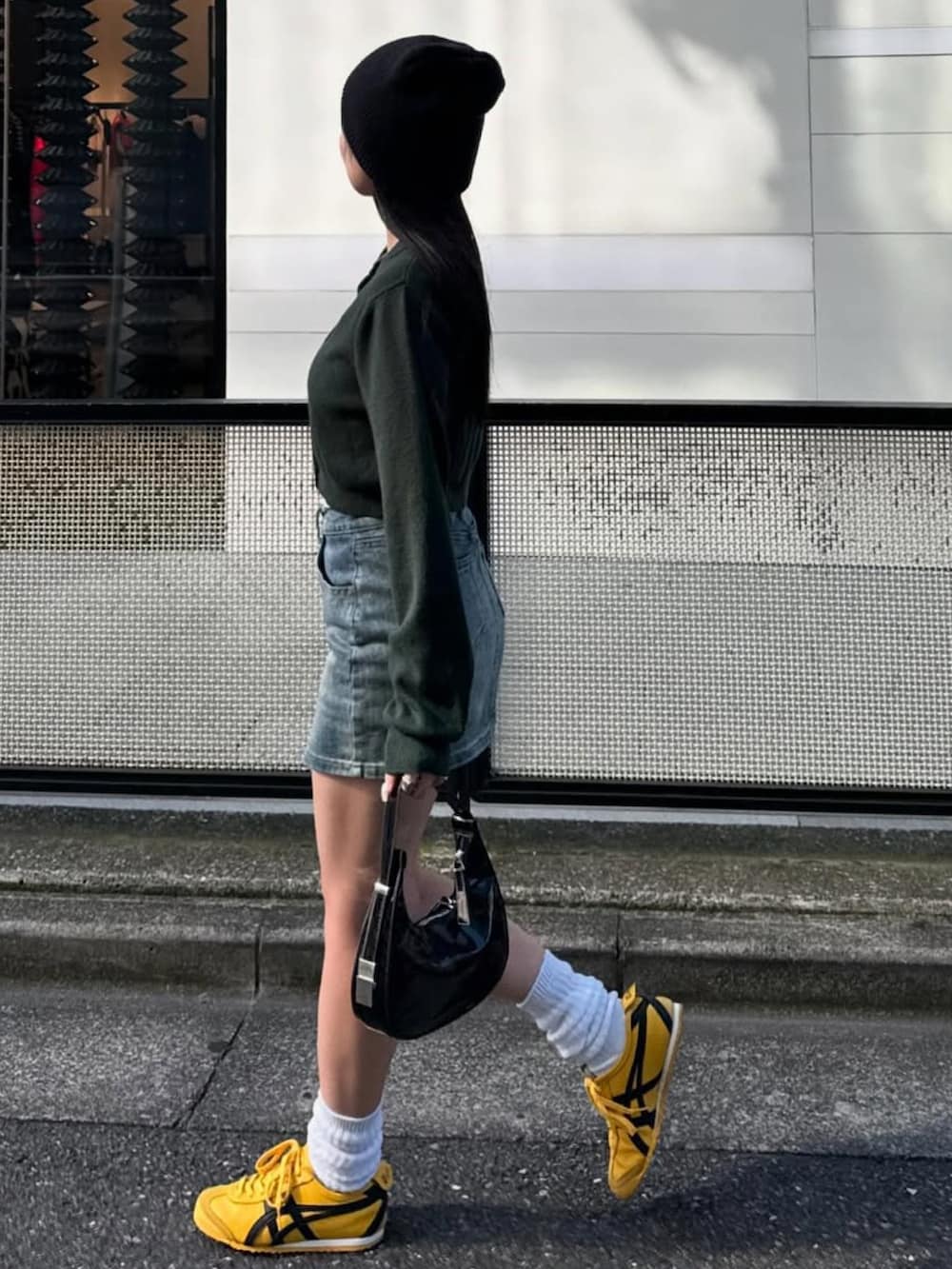 グリーン系のカーディガン/ボレロ、イエロー系のスニーカーを着用したレディースの冬コーディネートの2枚目の写真