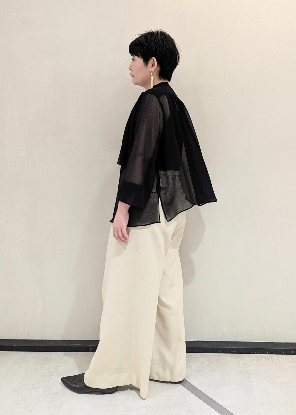 ブラック系のハンドバッグ、ブラック系のパンプス、ホワイト系のその他パンツを着用したレディースの春コーディネートの2枚目の写真