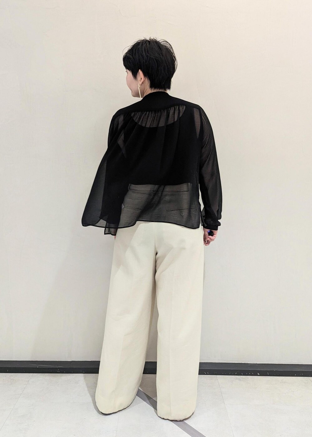 ブラック系のハンドバッグ、ブラック系のパンプス、ホワイト系のその他パンツを着用したレディースの春コーディネートの3枚目の写真