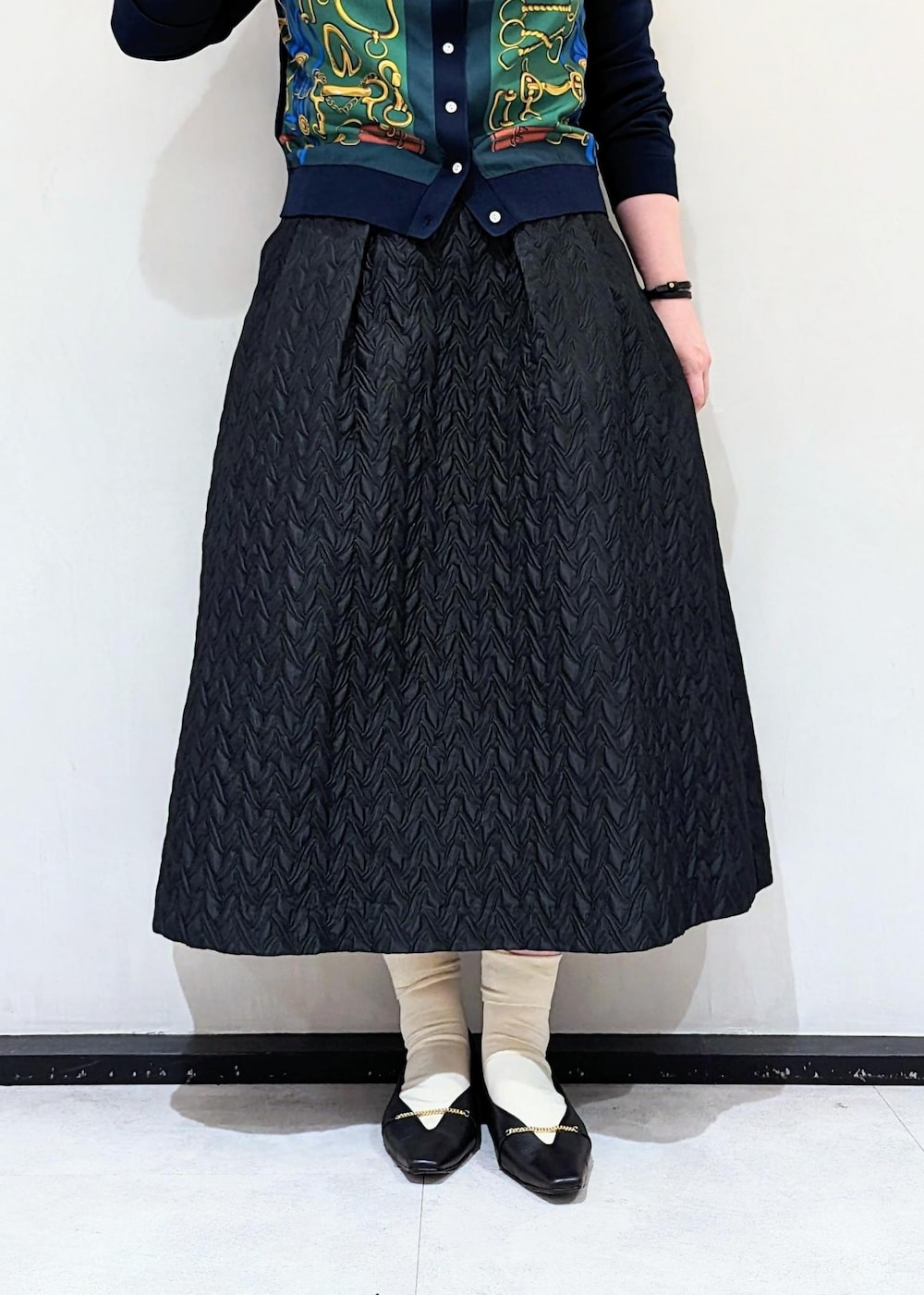 グリーン系のカーディガン/ボレロ、ブラック系のパンプス、ベージュ系のショルダーバッグを着用したレディースの夏コーディネートの5枚目の写真