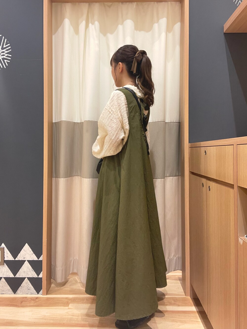 ホワイト系のシャツ/ブラウス、グリーン系のワンピース、ブルー系のデニムパンツを着用したレディースの秋コーディネートの2枚目の写真