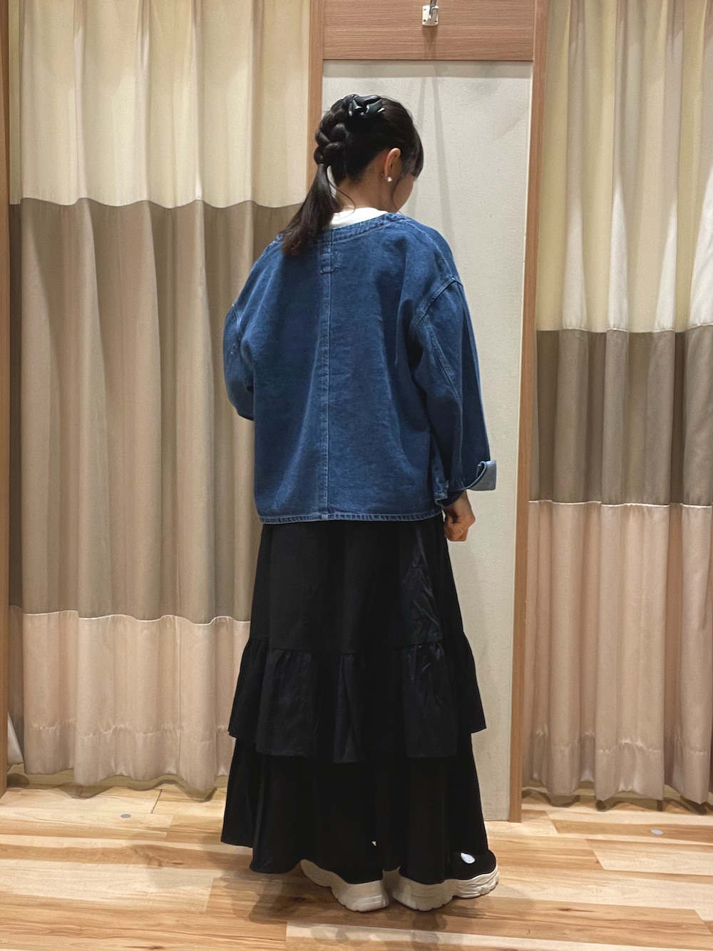 ブルー系のノーカラージャケット、ホワイト系のTシャツ/カットソー、ブラック系のスカートを着用したレディースの秋コーディネートの3枚目の写真