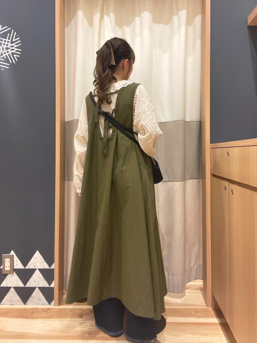 ホワイト系のシャツ/ブラウス、グリーン系のワンピース、ブルー系のデニムパンツを着用したレディースの秋コーディネートの3枚目の写真