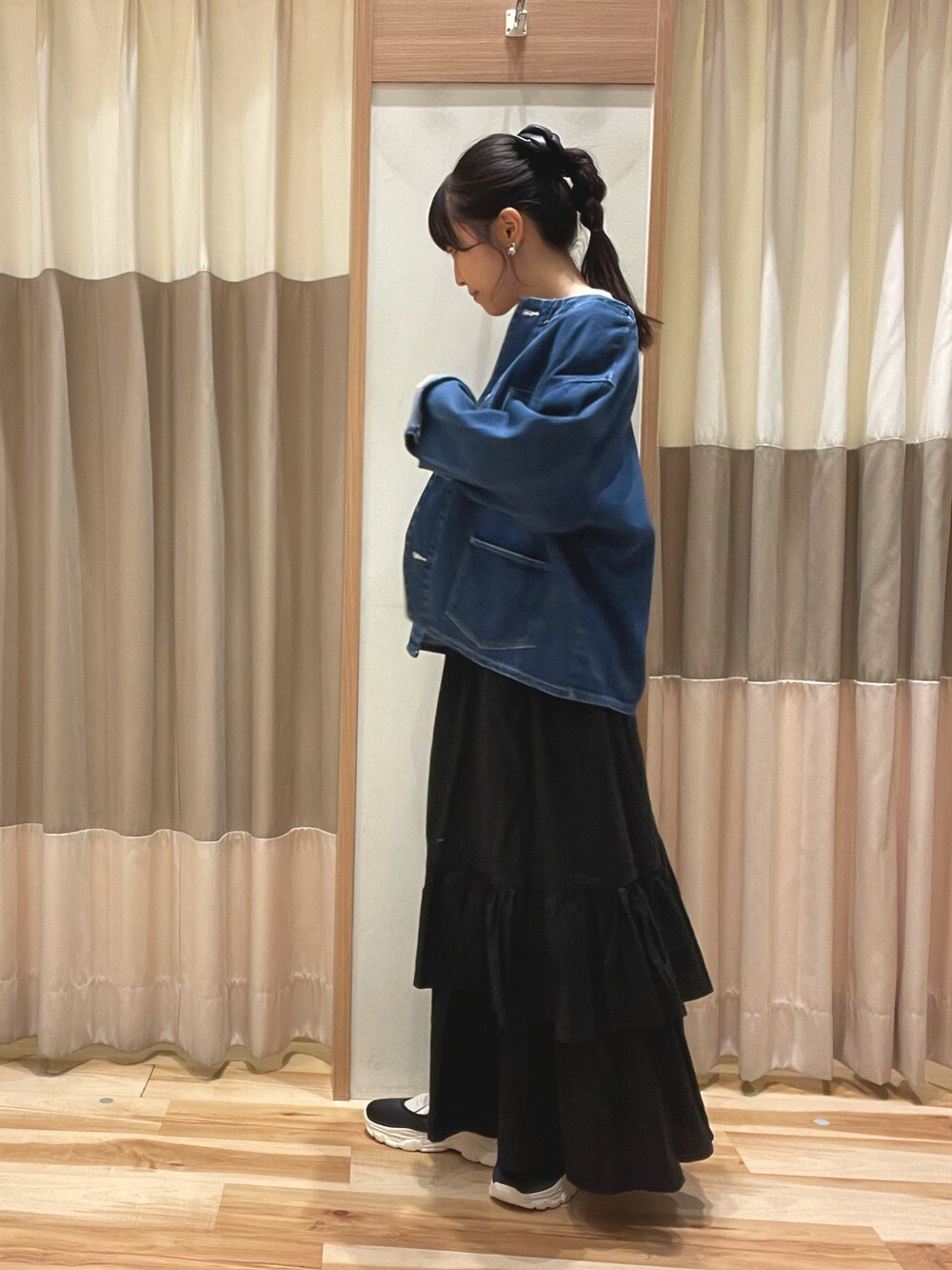 ブルー系のノーカラージャケット、ホワイト系のTシャツ/カットソー、ブラック系のスカートを着用したレディースの秋コーディネートの2枚目の写真